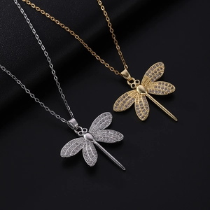 Macro shot of gold and silver dragonfly pendants featuring micro-pave cubic zirconia