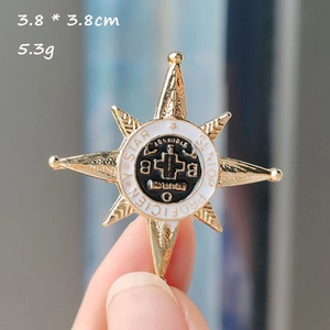 Detail view of gold octagonal star badge brooch with black and white enamel 3.8cm