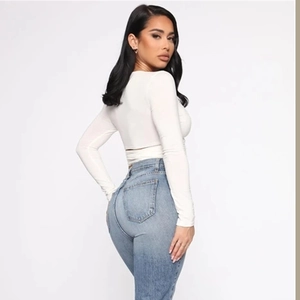 Detaillierte Rückansicht eines schmal geschnittenen weißen Langarm-Crop-Tops mit Schnürung