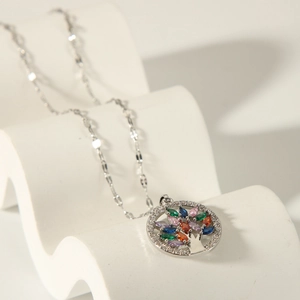 Close-up of tree of life pendant with colorful zircon leaves and crystal border