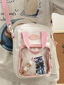 White and pink Ita bag with clear PVC window for doll display and adjustable strap