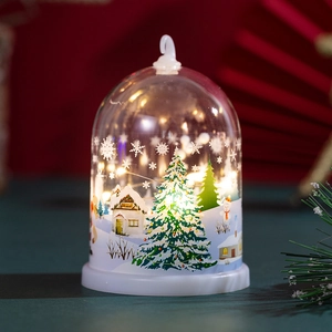 Close-up of lighted Christmas dome lamp with festive snowy forest scene and warm LED