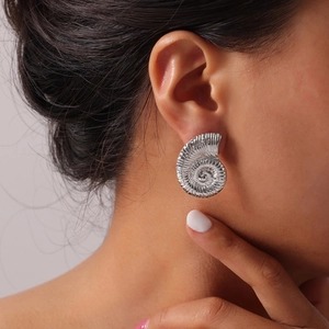 Minimalist silver nautilus spiral stud earrings with geometric shell texture design