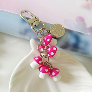 Macro shot of cute pink mushroom pendants with silver lobster clasp and butterfly tag