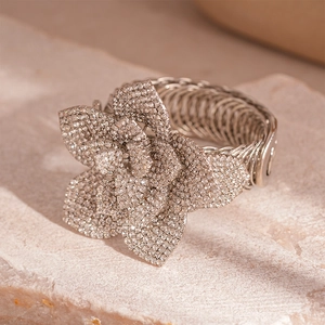 Macro shot of silver flower cuff bracelet with sparkling diamonds on stone base