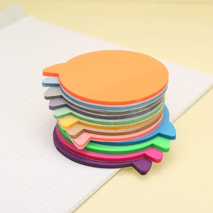 Note adesive in PET colorate a forma di fumetto su un taccuino a quadretti per indicizzare
