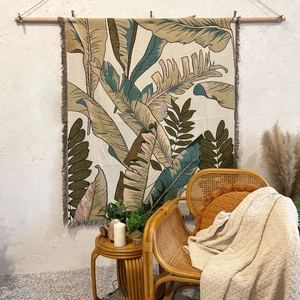 Detail of bohemian jacquard blanket with tropical leaf pattern and fringe tassels