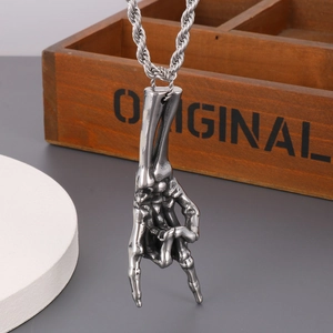 Macro shot of silver skull hand rock gesture pendant with stainless steel twist chain