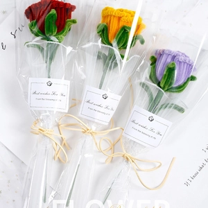 Handmade pipe cleaner rose bouquet in red, yellow, and purple with gift packaging