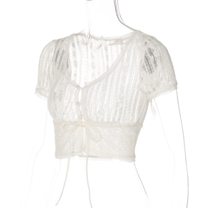 Dettaglio di crop top in pizzo bianco con scollo a V, lacci frontali e trama floreale fine