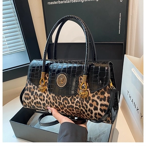 Detail of leopard print handbag with croc leather, gold lion head hardware, and strap