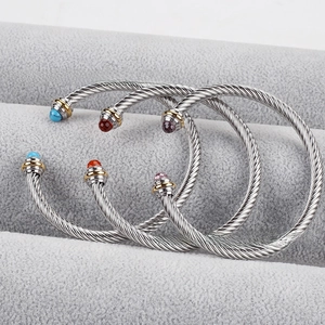 Macro detail of three cable twist bracelets featuring silver wire and colorful gemstone tips