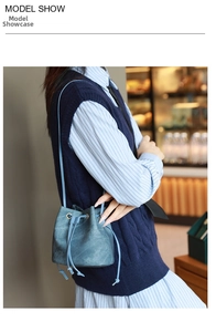 Close-up of blue-grey drawstring bucket bag in soft suede with vintage metal eyelet details