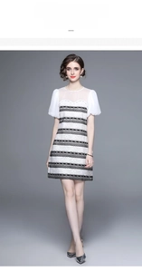 Detail of elegant black and white lace dress with sheer mesh neckline and puff sleeves