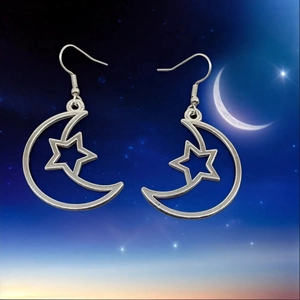 Detailed close-up of silver crescent moon and star drop earrings with hook fasteners