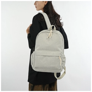 Detail view of light grey corduroy backpack showing side profile and shoulder straps