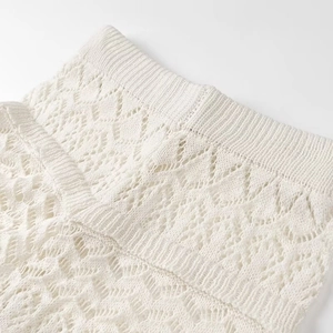 Detail of hollow-out knit pattern and elastic waistband on beige knit shorts set