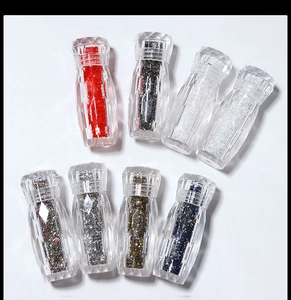 Macro view of assorted colorful iridescent nail art micro beads in clear diamond cut jars