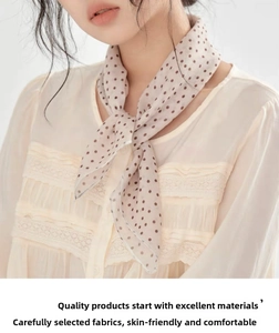 Detailed view of apricot cotton linen scarf with brown polka dots and lace trim necktie