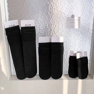 Three pairs of black slimming compression socks in different lengths with retail tags