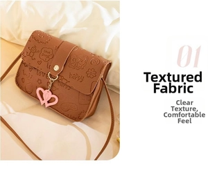 Close-up of brown PU leather bag with embossed cartoon patterns and a pink heart charm