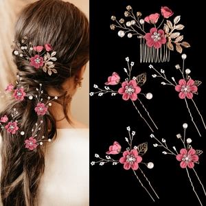 Close-up of pink floral hair accessories with gold leaves and bridal pearls detail