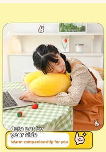 Detailed close-up of a plush yellow heart-shaped pillow showing its soft texture and use