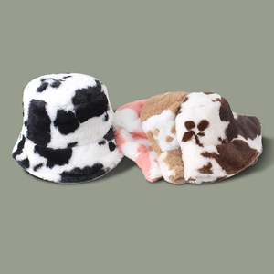 Détail de bobs en peluche à motif vache en noir et blanc, rose et blanc, et marron et noir