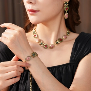 Détails d'un ensemble de bijoux vintage avec portraits et gemmes portés par un modèle