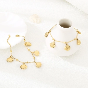 Detailed close-up of gold-plated starfish and tropical fish charms on a resort-style bracelet