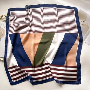 Detail of silk satin scarf with navy and brown geometric stripes and smooth texture