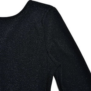 Close-up of black sparkly glitter fabric on long sleeve jumpsuit shoulder and sleeve detail