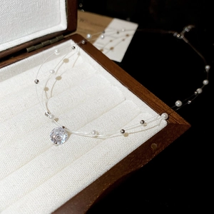 Close-up of double-layered necklace with zircon pendant and pearls in a jewelry box