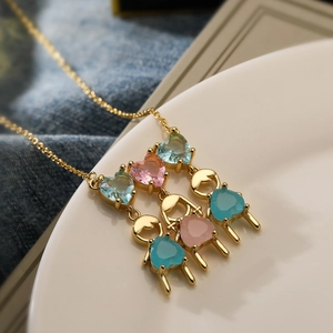 Gold-plated heart necklace with colorful zircon boy and girl charms on white plate