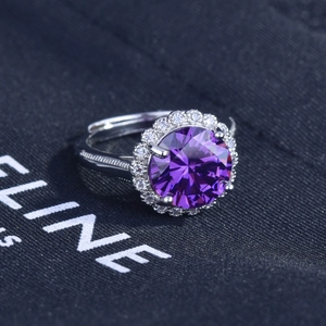 Macro shot of 5 carat round purple gemstone ring with halo diamonds and engraved silver band