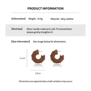 Detail view of brown faux leather C-shaped earrings with gold accents and size dimensions