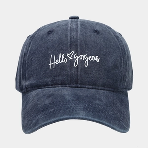 Detailed close-up of Hello Gorgeous embroidery on a navy washed denim baseball cap