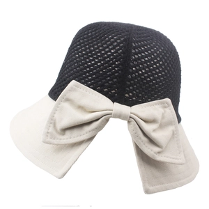 Detail of breathable mesh crown and large bow on a wide-brim bicolor sun hat