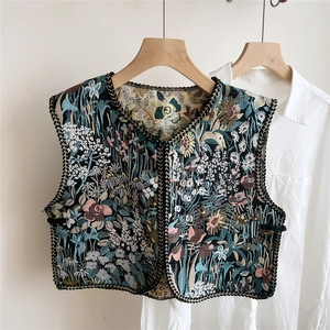 Detail of ethnic style floral jacquard vest with woven trim on soft cotton fabric