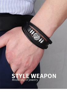 Détail d'un bracelet multicouche pour homme en cuir tressé avec breloque en métal gravé