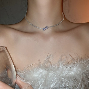Close-up of a silver double-layered heart pendant necklace with zircons worn by a model