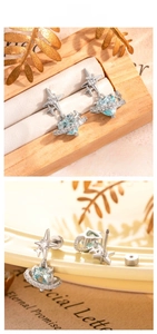 Detail of light blue heart zircon planet earrings with stainless steel screw back