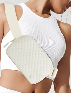 Close-up of a white quilted nylon belt bag worn cross-body style on a sporty model