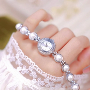 Elegant pearl bracelet watch for women with sparkling crystal dial on a model's wrist