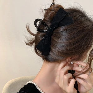 Elegant black velvet bow hair claw clip for thick hair shown from the back hairstyle view