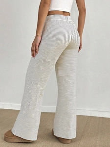 Detail view of women's black and white striped high waist flared knit trousers on a model