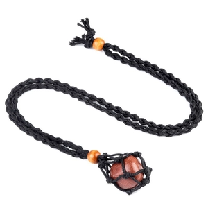 Dettaglio della collana con sacchetto a rete intrecciata a mano e pietra dorata marrone