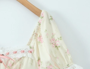 Dettaglio vestito in chiffon a fiori con maniche a sbuffo, bordi in pizzo e nastri rosa