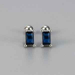 Detail of silver screw earrings featuring rectangular blue zircon stones in four-prong setting