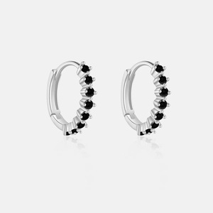 Close-up of S925 silver hoop earrings with round black zircon stones and polished finish